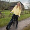 smiling lady riding The Cruiser electric bike on a rural track