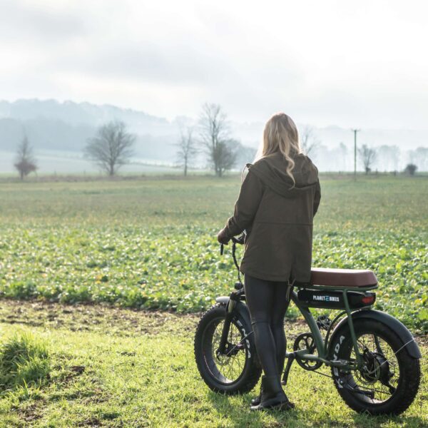 lady admiring countryside views standing next to Planet EBikes Cruiser V2 electric bike